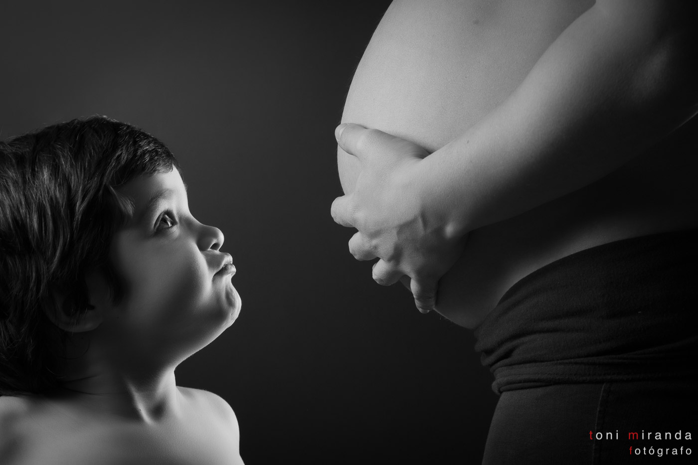 Niño viendo barriga de su madre embarazada
