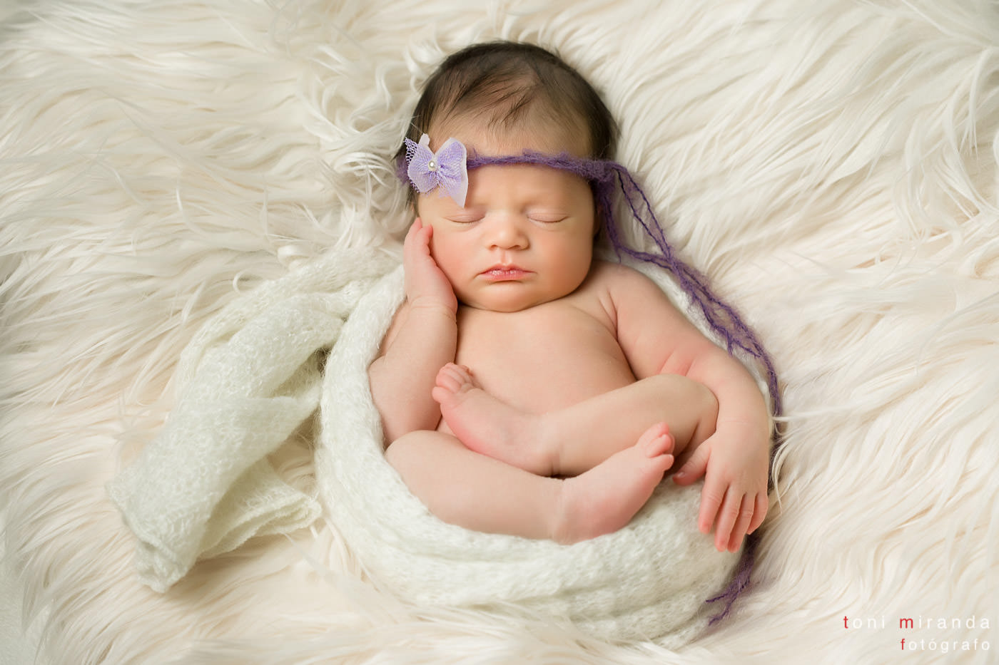 niña recién nacida durmiendo en un flokati
