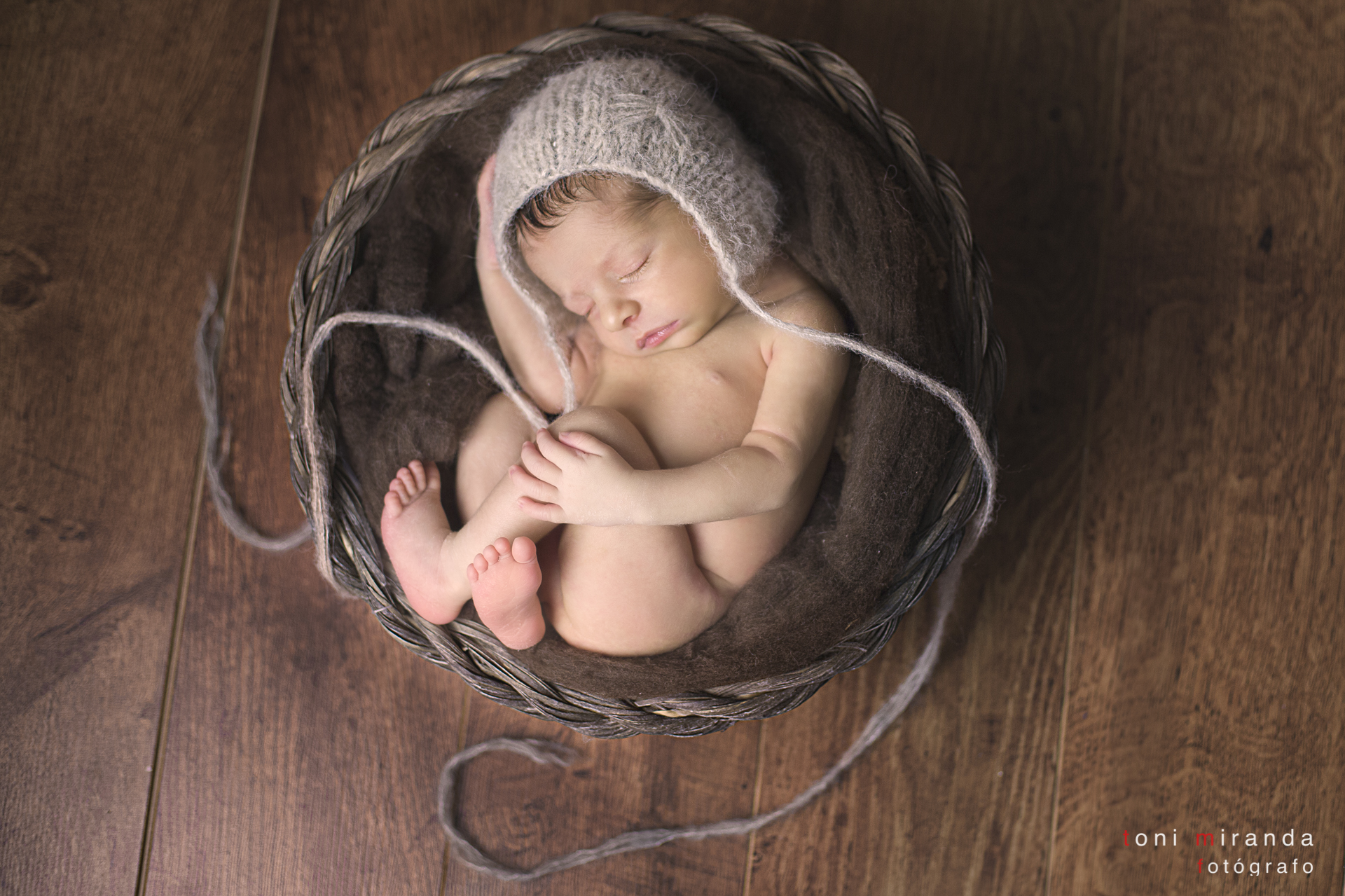 recien nacido metido en cesta en reportaje de newborn