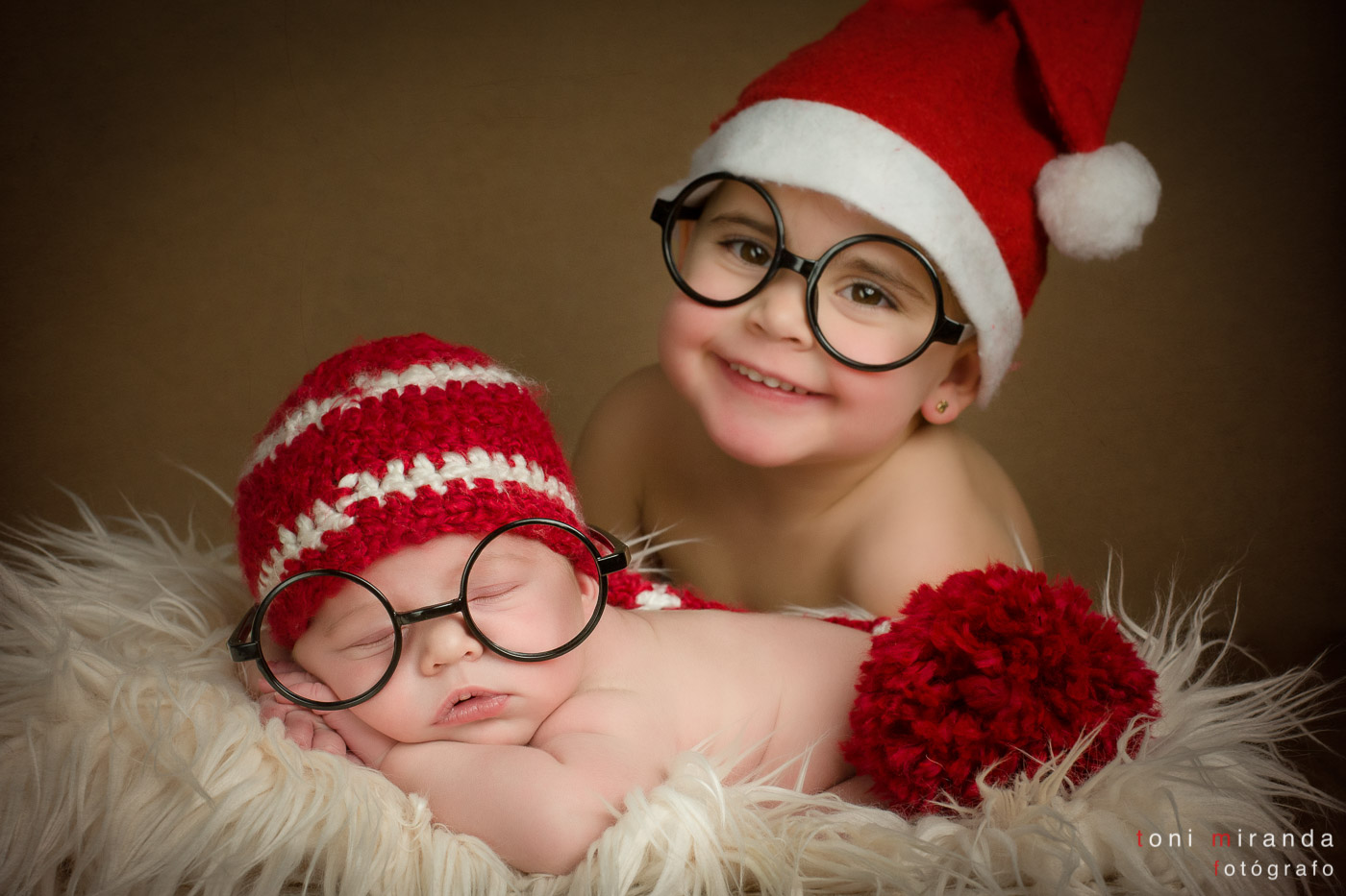 bebe recien nacido con su hermana en foto tipica de navidad