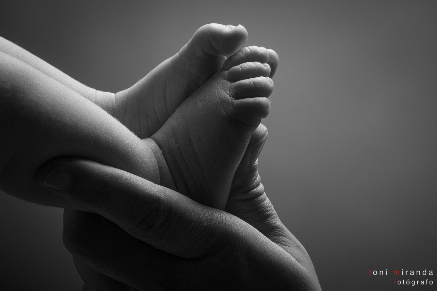 pies de bebe con manos de mama