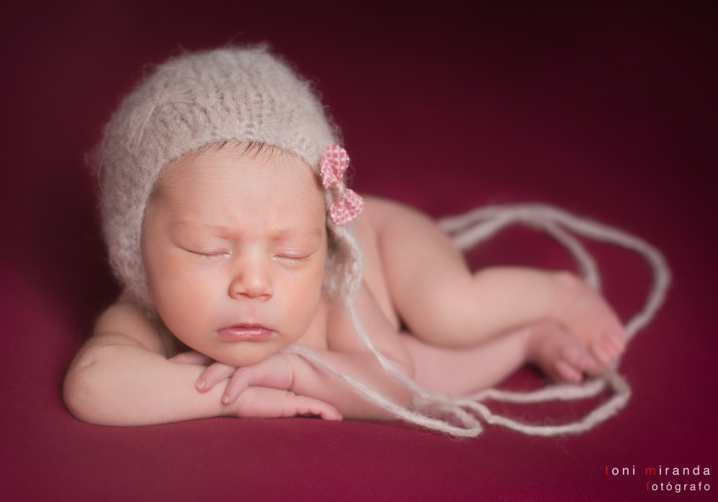 beba durmiendo con gorrito apoyada en brazos