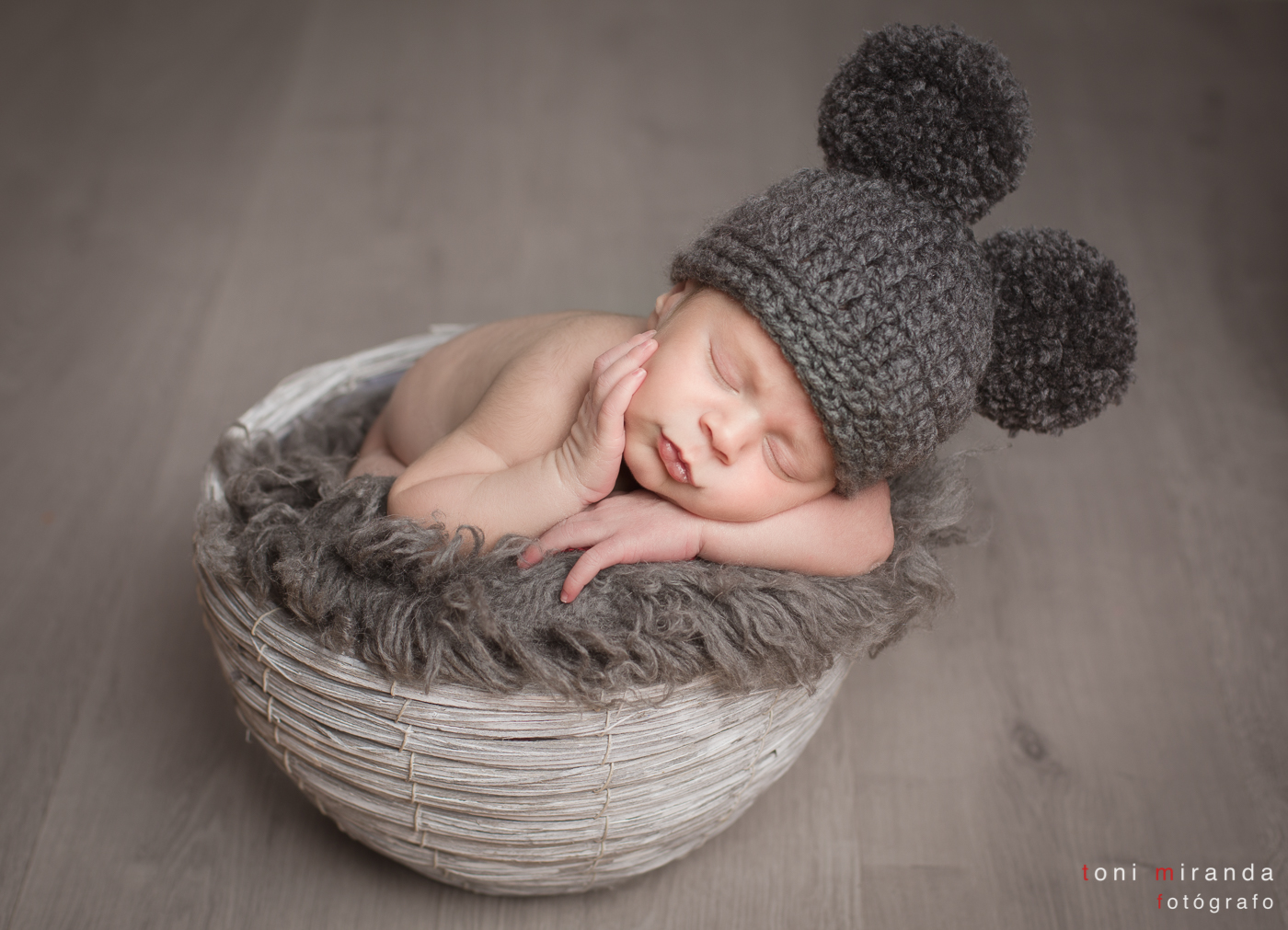 bebe durmiendo en cesta con gorrito pompones