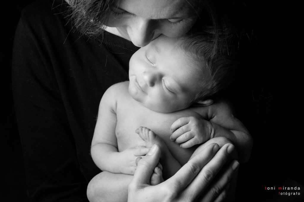 bebe sonriendo en los brazos de su madre