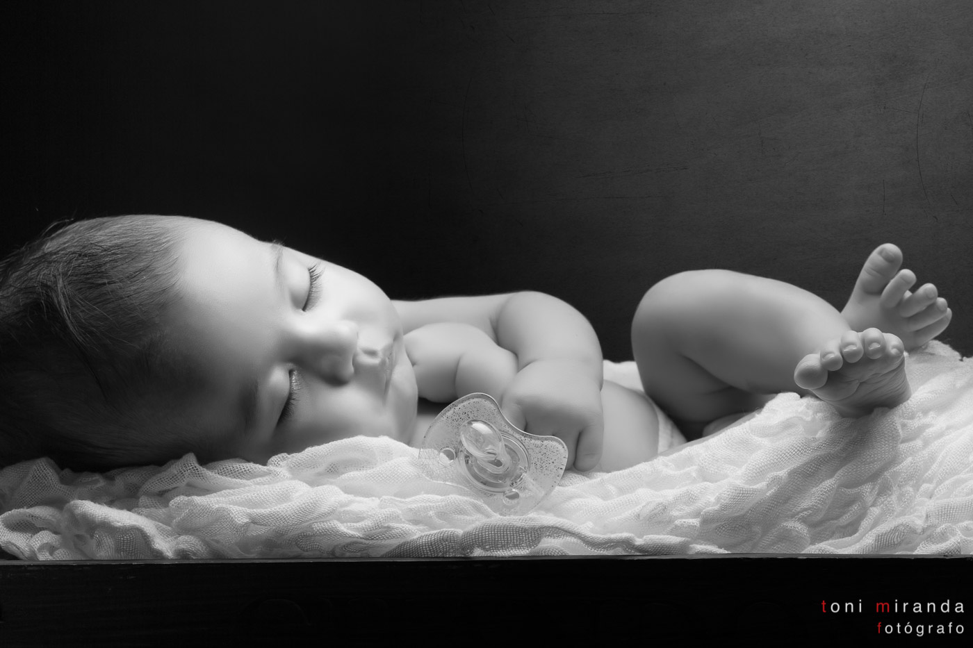 bebe de un mes durmiendo en cuna de madera con chupete