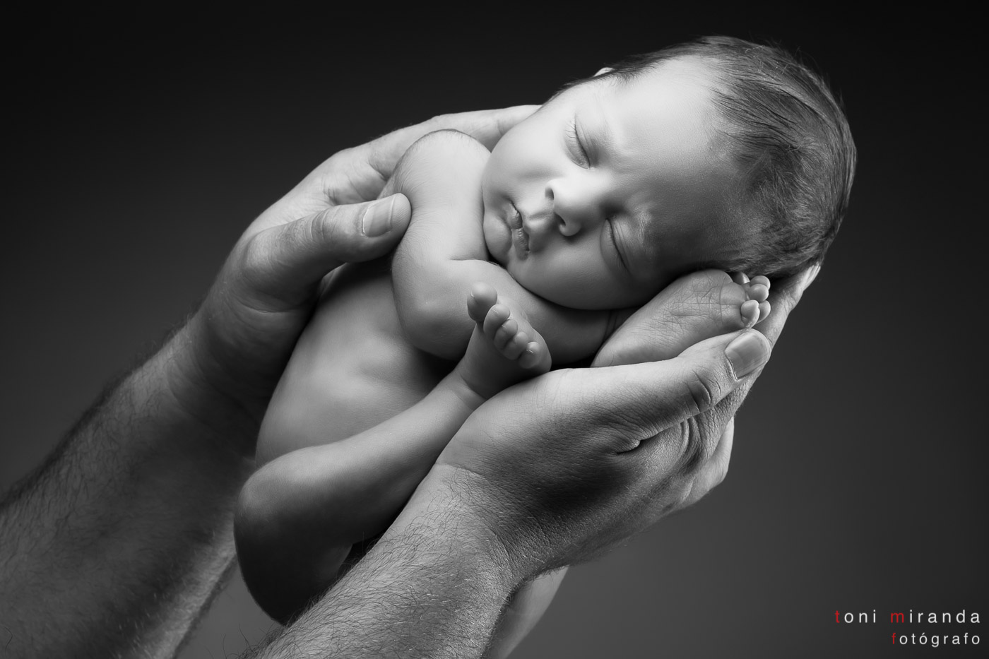 bebe recién nacido en manos de su padre